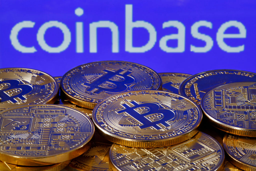 PARIS, FRANCE - APRIL 13: In this photo illustration, a visual representation of the digital cryptocurrency Bitcoin is displayed in front of the Coinbase cryptocurrency exchange platform logo on April 14, 2021 in Paris, France. Coinbase, America&#039;s leading cryptocurrency exchange, arrives on Wall Street on Wednesday April 14 as part of a &#039;direct introduction&#039;. An IPO, eagerly awaited by crypto enthusiasts, which could value the Californian company at more than 100 billion dollars. This is the most anticipated event on Wall Street since Facebook came public: the Coinbase platform, specializing in cryptocurrencies, entered the Nasdaq at a price of $ 250 per share. It&#039;s the biggest introduction for an American business since Uber in 2019.Taking advantage of exploding demand for digital currencies, Coinbase said last week that it expects to make a profit of $730 million to $800 million in the first quarter of 2021, more than double the total profit in 2020. Revenues for the first three months of 2021 have likely exceeded last year&#039;s, to nearly $1.8 billion. (Photo illustration by Chesnot/Getty Images)