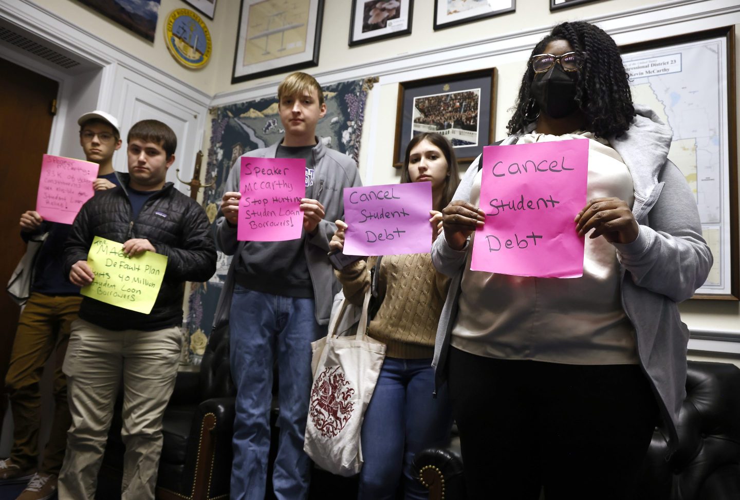 Students hold up signs that say &quot;Cancel Student Debt&quot; and similar messages during a protest in then-House Speaker Kevin McCarthy&#039;s office.