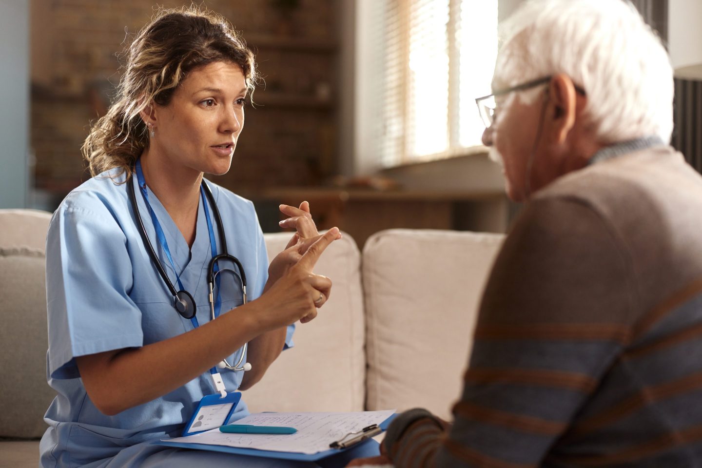 Mid adult female nurse counting the things mature man has to do to preserve his health during her home visit.